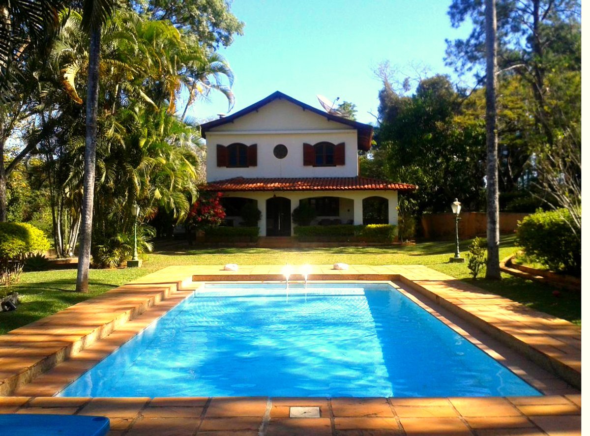 Casa e piscina da Chácara Gramado em um dia ensolarado
